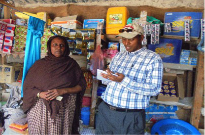 Mama Owlia a HSNP beneficiary from Elwak inside her shop. She's being interviewed by Hussein Alio- CDC, NDMA Mandera
